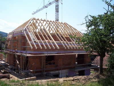 Dachstuhl in Walmdachform mit Baukran, Gesamtansicht des Rohbaus